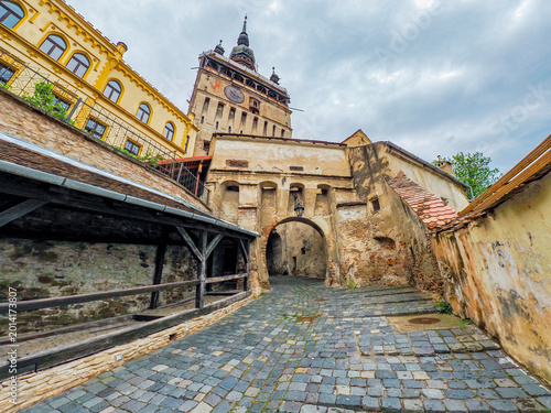 Foto Cobblestone street leading to Clock Tower in Sighisoara citadel, birthplace of C