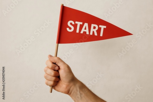 Hand holding small red flag with word start om white background. Beginning of race project business and challenge