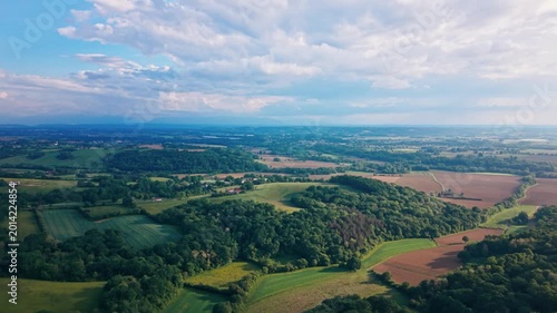 aerial view high above France reveals a stunning patchwork of lush wheat fields and rolling hills in a serene natural setting