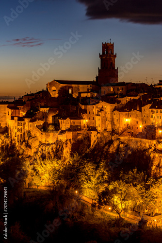 Nighttime view of a town with a clock tower and a steeple, Sovana, Tuscany, Italy, long exposure motion blur