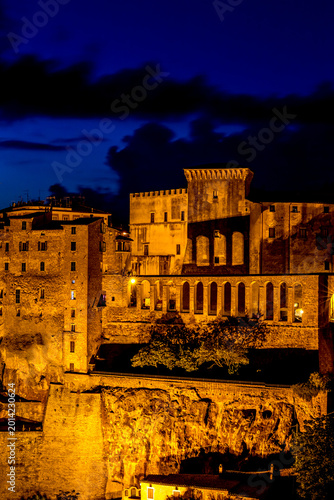 Nighttime view of a city with a clock tower and a clock tower, Sovana, Tuscany, Italy, long exposure motion blur