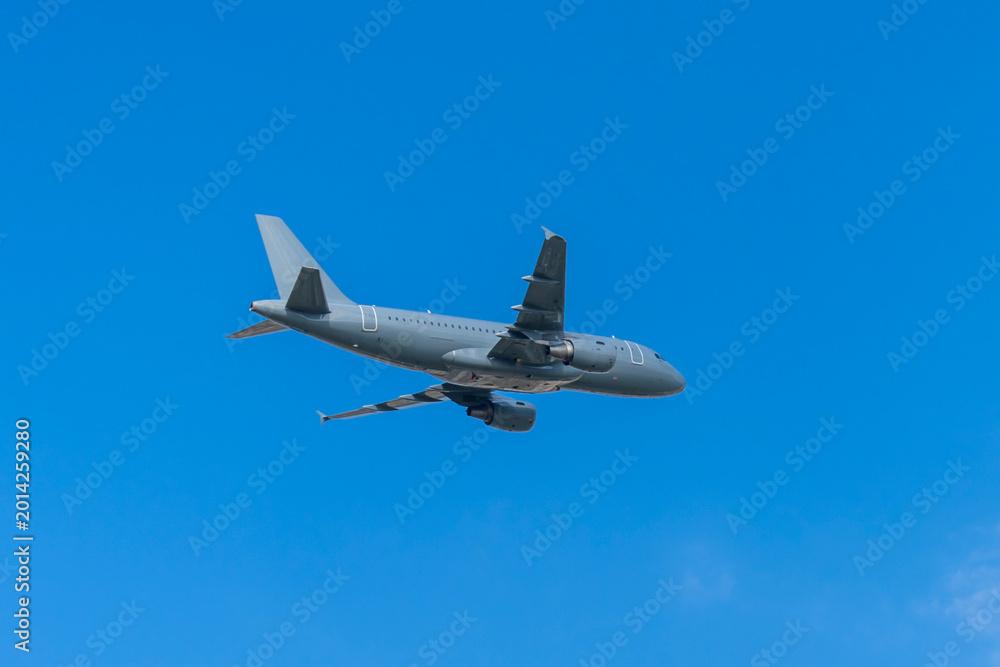 Fototapeta premium Gray military transport plane flying in the blue sky