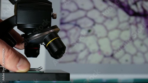Laboratory Microscope with Digital Cell Image on background Computer Screen