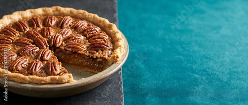 Pecan Pie on slate with copy space isolated on teal background.