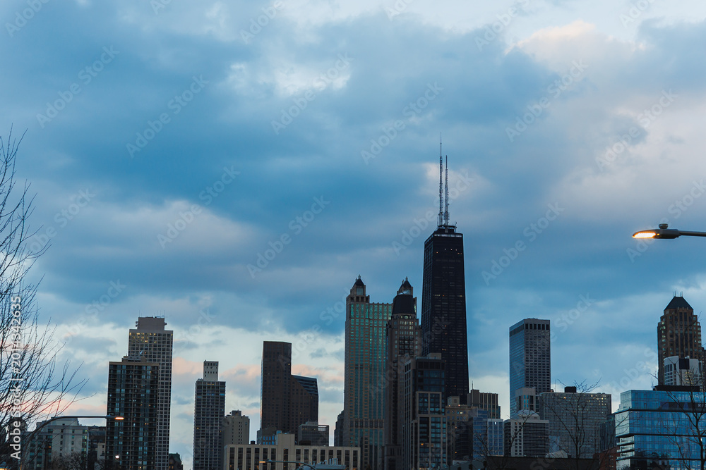 Fototapeta premium View of city skyline with tall buildings and clouds during evening hours in urban setting