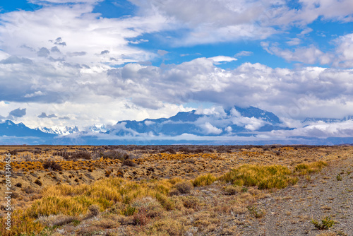 Fotografia Scenic view of the snow-capped Andes mountains and dramatic cloud formations ove