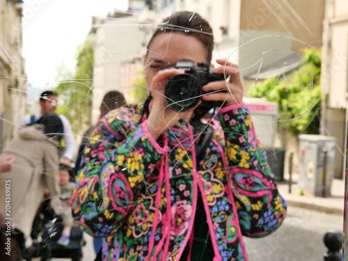 Foto Creative self-portrait of a female photographer reflected in a scratched outdoor mirror on a city street