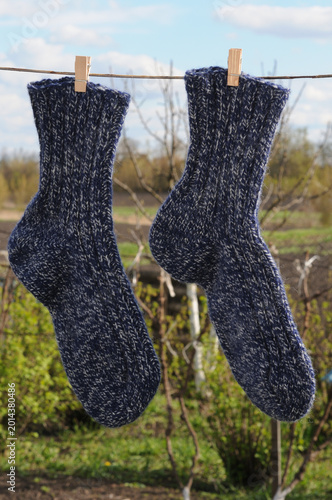 Woolen socks hanging on a clothesline in the garden.