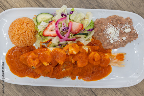 Foto Overhead view of hearty plate of whole red snapper fish topped with shrimp, smot