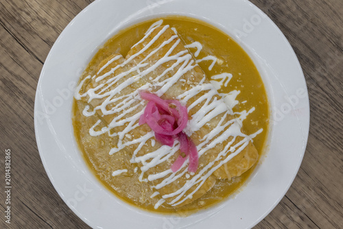 Canvas Print Overhead view of hearty plate of enchiladas suizas smothered in green sauce to s