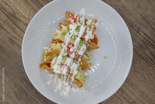 Фотография Overhead view of hearty plate of potato tacos smothered in sour cream, lettuce,