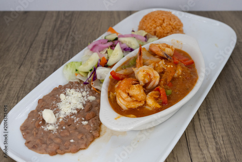 Obraz na plátne Hearty plate of shrimp diablo smothered in ranchero sauce, beans, and rice to sa