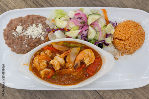 Bild auf Leinwand Overhead view of hearty plate of shrimp diablo smothered in ranchero sauce, bean