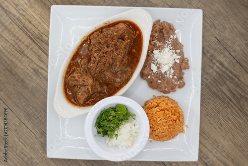 Canvas Print Overhead view of hearty plate of birria smothered in consome, beans, and rice to