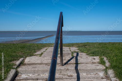 Blick über den Deich aufs ostfriesische Wattenmeer nähe Bensersiel mit Blick auf die Nordseeinsel Langeoog.