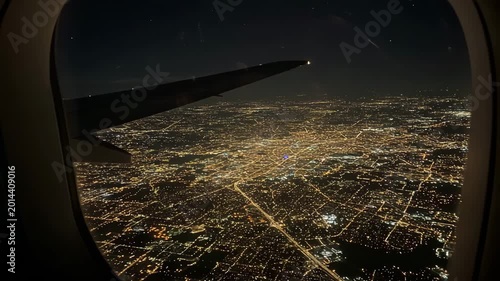 Aerial view of city lights at night from airplane window  