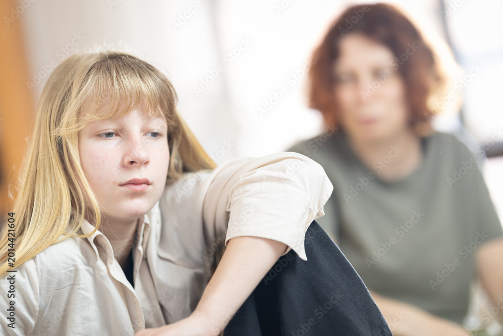 Fototapeta premium Teenager feeling sad with parent in background
