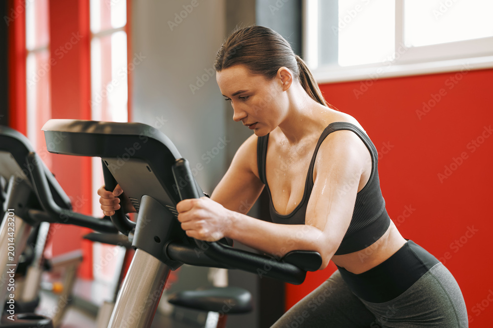 Fototapeta premium Athletic woman with sweat on her body training in gym