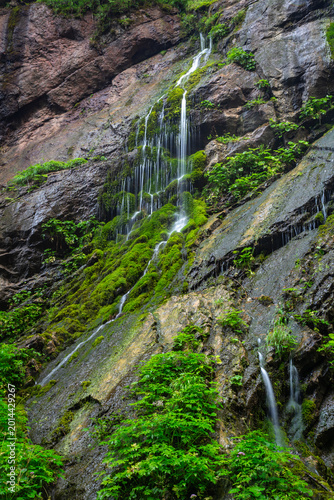 A view of a waterfall cascading down rocks in Wimbachklamm, a popular travel spot in Ramsau, Germany.
