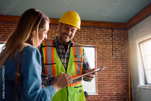 Obraz na plátně Happy building contractor and female homeowner signing home renovation contract
