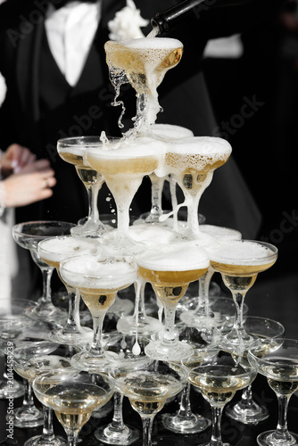 Фотография Champagne glass tower with cascading bubbly champagne being poured from the top