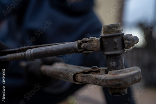 Foto Two old rusty pipe wrenches clamping a threaded metal pipe fitting, close-up view of plumbing repair and maintenance tools