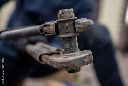 Fotografi Two old rusty pipe wrenches clamping a threaded metal pipe fitting, close-up view of plumbing repair and maintenance tools