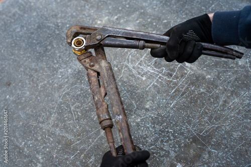 Obraz na płótnie Two old rusty pipe wrenches clamping a threaded metal pipe fitting, close-up view of plumbing repair and maintenance tools