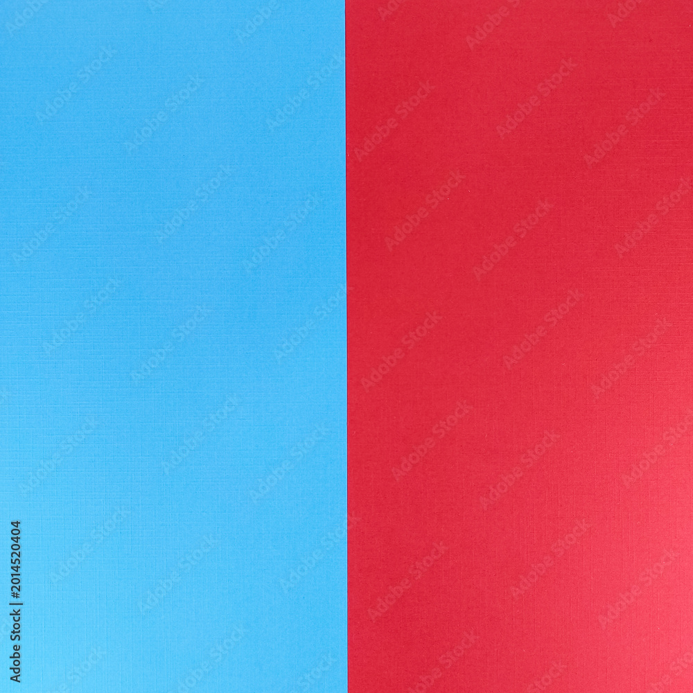 Fototapeta premium Blue and red split background showing a vertical two-tone textured paper surface ideal for minimal design, banners, posters, layouts and graphic projects requiring clean contrast and copy space.