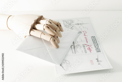 wooden sketching hand holding paper letter