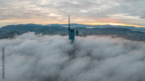 Aerial view time lapse 4k video of Kuala Lumpur city center view during dawn overlooking the city skyline in Federal Territory, Malaysia with epic low cloud glows on sunrise. 