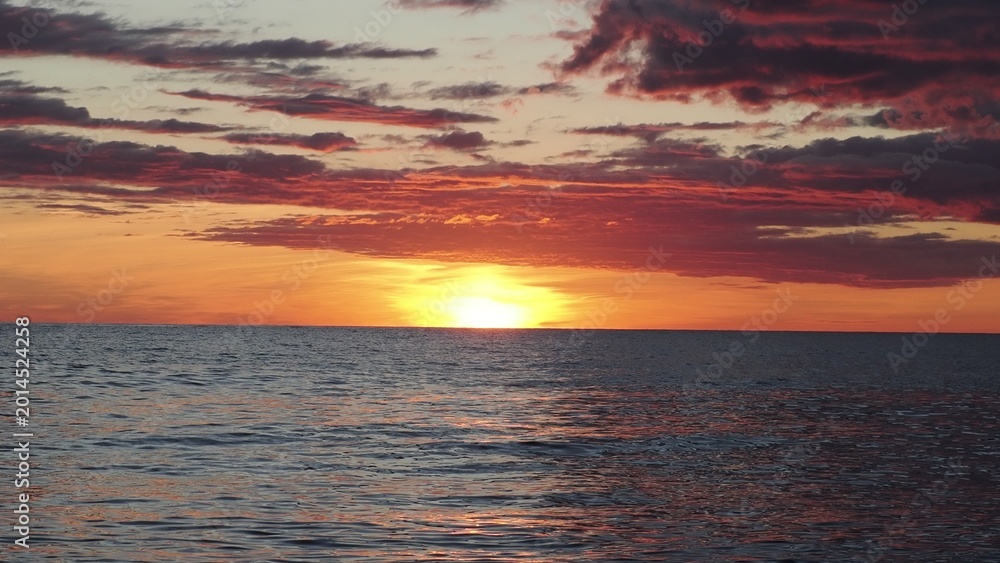 Fototapeta premium Dramatic golden beach sunset sky and tropical sea background. yellow sun sets behind the lake. Beautiful sunrise on the lake. Protect the environment. sun sets ha horizon