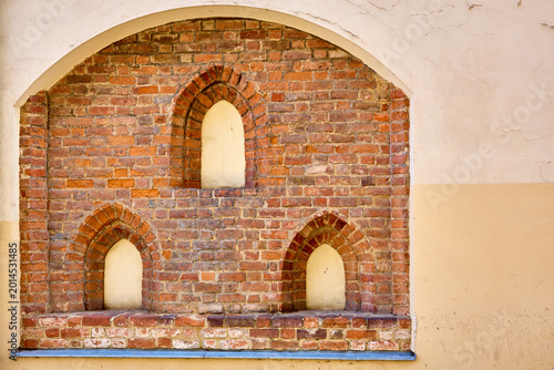 Quadro su tela Vintage brick wall with arched niches in historic architectural design