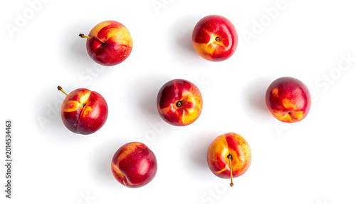 Seven ripe nectarines with vibrant red and yellow skin, glistening with water droplets, arranged in a circular pattern on a clean white background