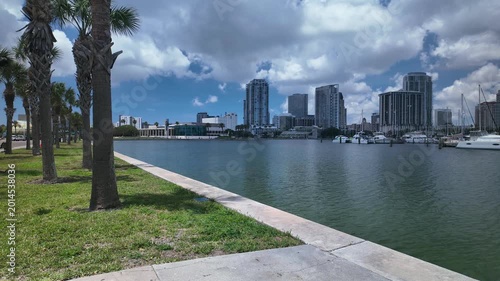 Time lapseView from Albert Whitted Playground into south yacht basin in St. Petersburg, FL. Towards marina, docked boats and Skyline of downtown. Masts and sails against a blue sky. Calm blue water wi