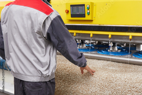 Male worker cleaning carpet on automatic washing machine equipment and dryer in the Laundry room. professional washing service