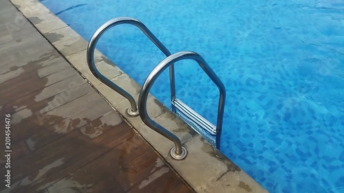 Entering a Quiet Poolside Scene with Metal Handrails and Clear Blue Water