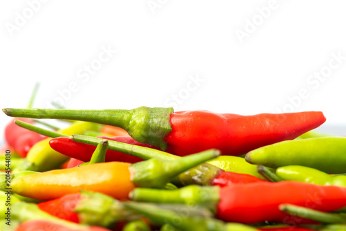 Foto Heap of fresh red and green bird's eye chilies on white background