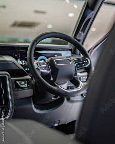 Luxurious Modern Car Interior Focus on Steering Wheel and Dashboard.