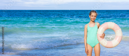 фотографія Young girl holding a floatation ring at a beach on a sunny day