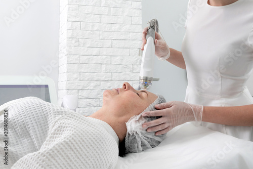 Quadro su tela Mature woman receiving laser treatment in cosmetology clinic