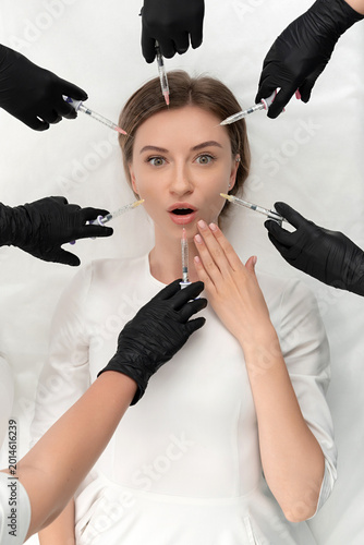 Cuadro en lienzo Conceptual beauty and cosmetology image of hands of several doctors holding syringes