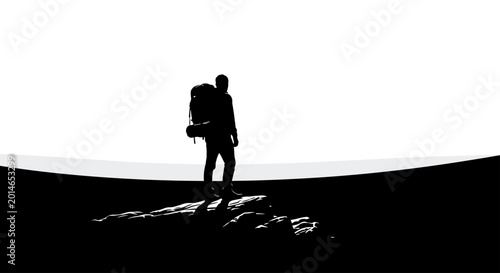 Silhouette of a hiker with a large backpack stands on a rocky ledge