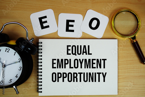Fotografía EEO Equal Employment Opportunity text written on notepad with magnifying glass a