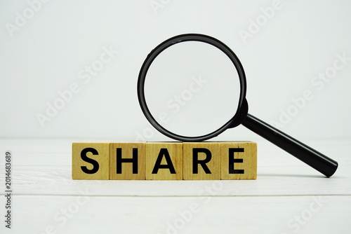 Konstfotografi SHARE alphabet letters with magnifying glass on wooden background