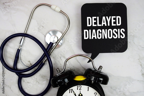 Obraz na plátně Delayed Diagnosis text with stethoscope and alarm clock on marble background