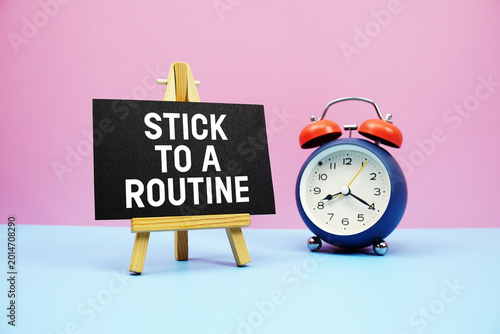Photos Stick To A Routine text with alarm clock on pink and blue background