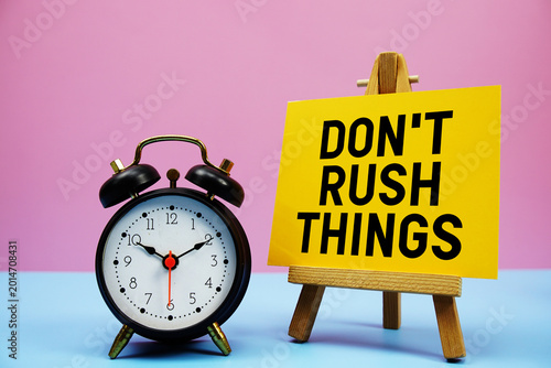 Foto Don't Rush Things text with alarm clock on pink and blue background