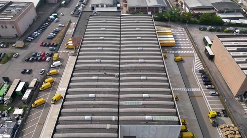 Hyperlapse drone footage of parcel distribution hub in San Giuliano Milanese, Lombardy, Italy. Urban logistics center and last mile delivery warehouse during active morning operations.