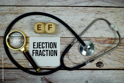 Fotografía Ejection Fraction (EF) text with stethoscope and magnifying glass on wooden back